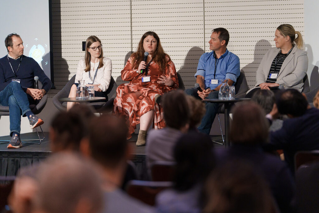 Three researchers on stage in panel discussion